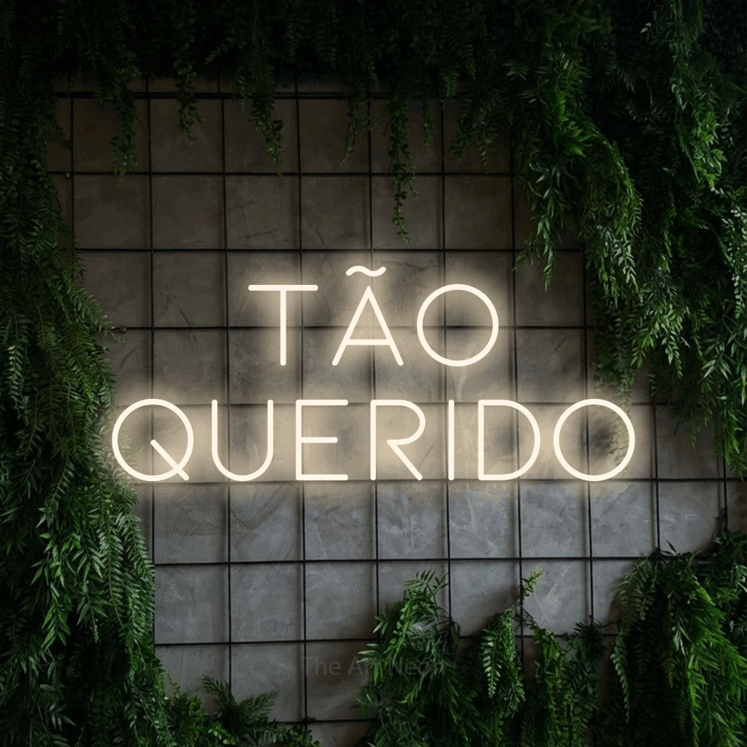 LED neon sign reading “tão QUERIDO”, arranged in 2 lines.