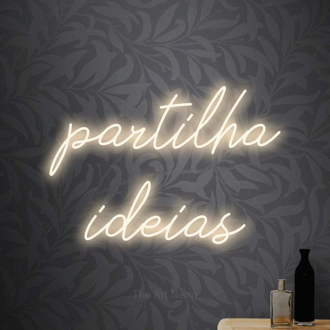 LED neon sign reading “partilha ideias”, arranged in 2 lines.