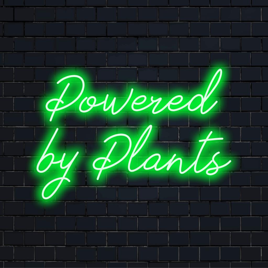 Placa de LED neon personalizada com os dizeres "Powered By Plants", perfeita para quem ama plantas e decoração neon ecológica.