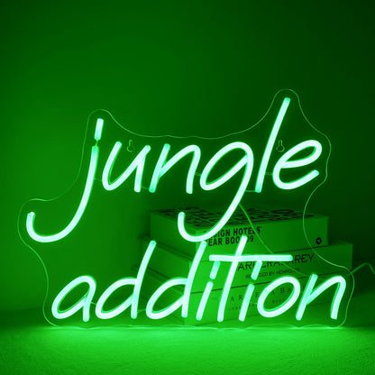 Uma vibrante placa de LED neon verde "Jungle Addition", colocada sobre um fundo de parede branca minimalista.