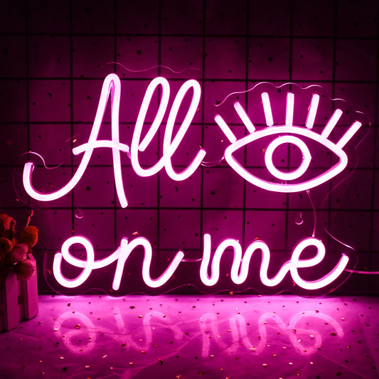 The image features a vibrant LED neon sign that spells out "All Eyes on Me" in a bold script font.