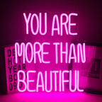 A imagem apresenta um letreiro de LED neon vibrante exibindo a frase "Você é mais que bonita".