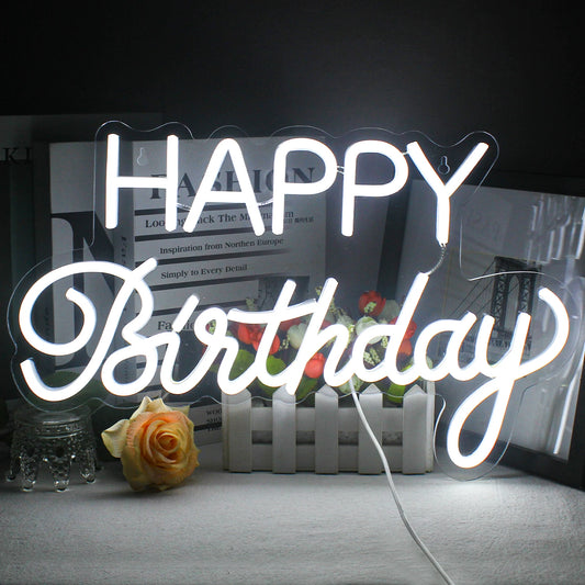 The image features a vibrant LED neon sign that spells out "Happy Birthday" in elegant, cursive lettering.
