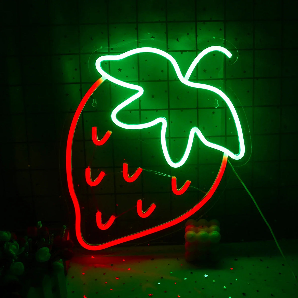 Um letreiro de LED neon vibrante no formato de um morango, com um corpo vermelho brilhante e folhas verdes exuberantes no topo.