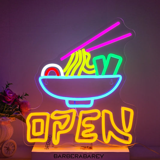 The image features a vibrant LED neon sign that reads "Open Ramen" in visually striking, glowing colors.