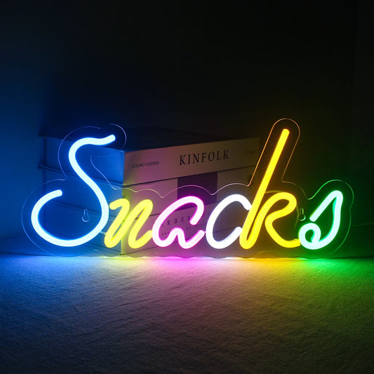 The image showcases a vibrant, handmade LED neon sign that reads "Colorful Snacks.