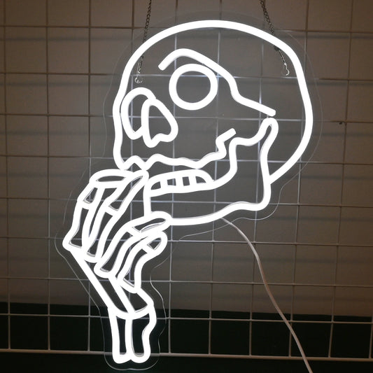 The image features a vibrant, handmade LED neon sign in the shape of a skull.