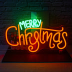 A glowing "Merry Christmas" LED neon sign, featuring bold, cursive lettering in bright red color.