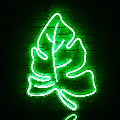 The image features a vibrant LED neon sign shaped like a green leaf.