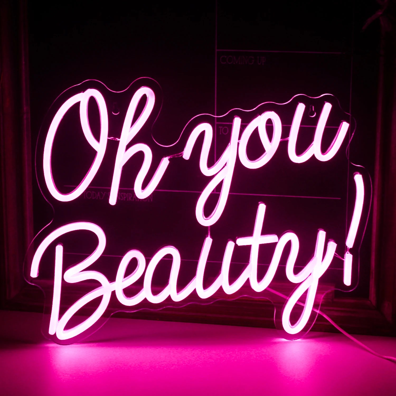 The image features a vibrant, handmade LED neon sign displaying the words "Oh You Beauty.