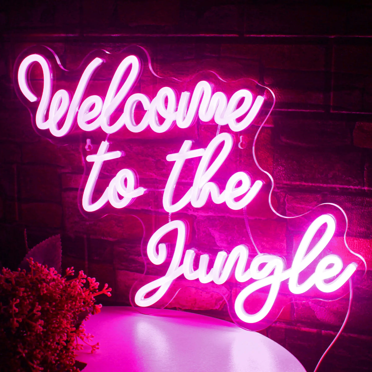 A imagem apresenta uma vibrante placa de LED neon com os dizeres "Bem-vindo à selva" em letras cursivas em negrito.