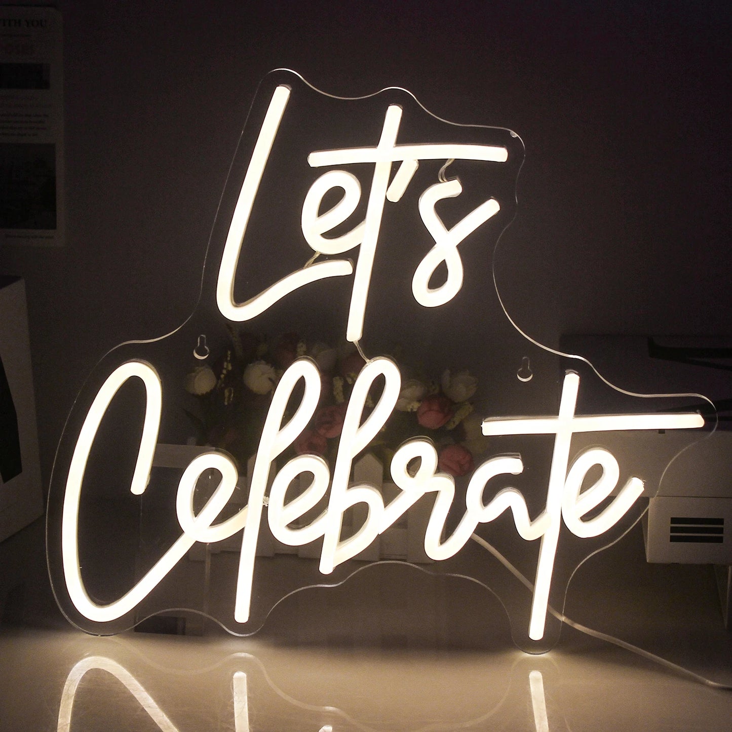 The image features a vibrant "Let's Celebrate" LED neon sign.