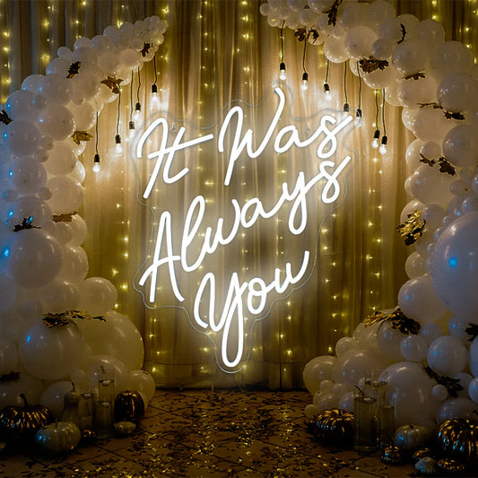 A vibrant LED neon sign displaying the phrase "It Was Always You" in elegant, flowing cursive script.