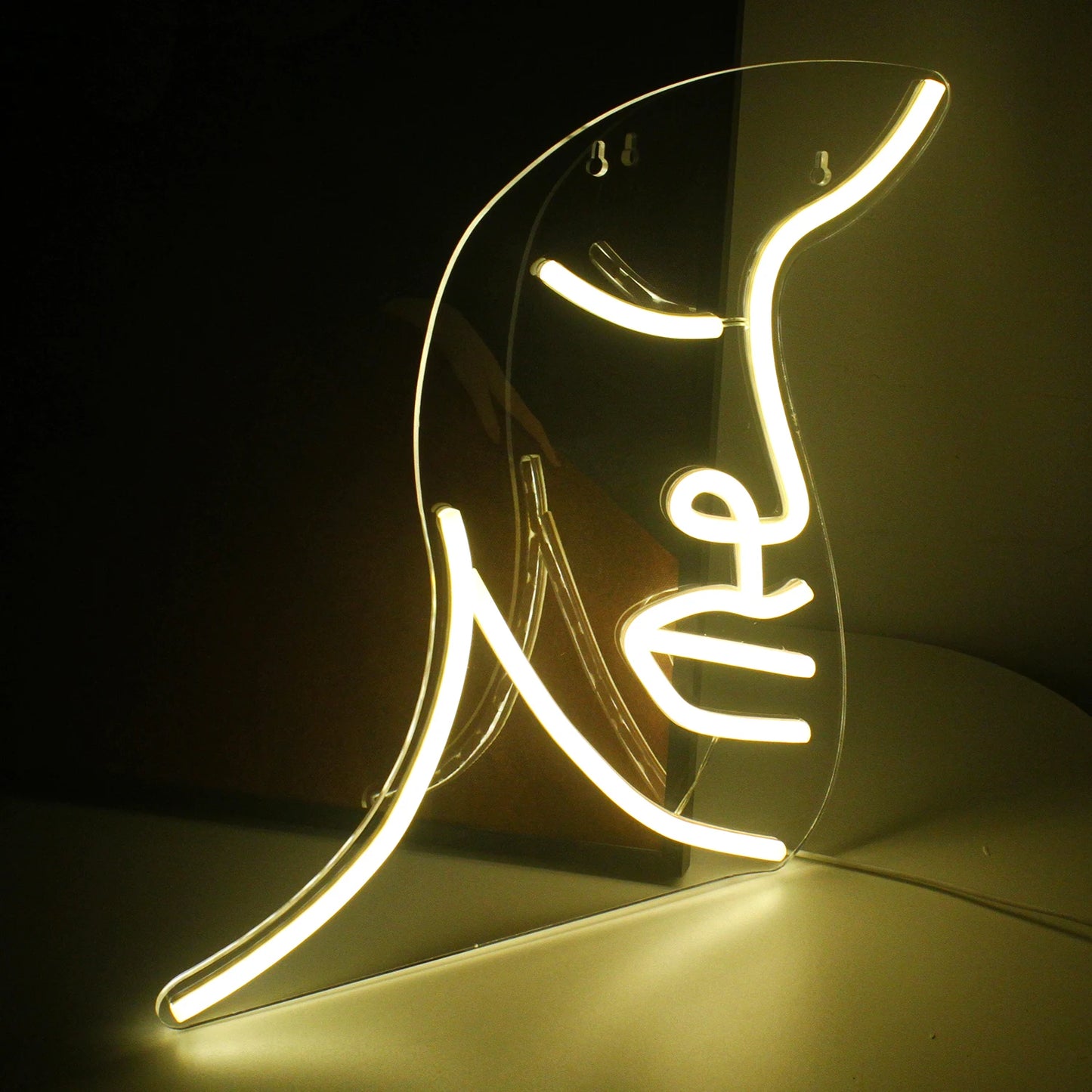 A vibrant handmade LED neon sign featuring a stylized illustration of a face.