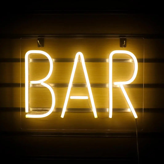 The image features a vibrant and eye-catching LED neon sign displaying the word "BAR" in bold, uppercase letters.