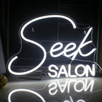 A imagem apresenta um letreiro de neon LED vibrante exibindo a palavra "SALON" em letras maiúsculas estilizadas.