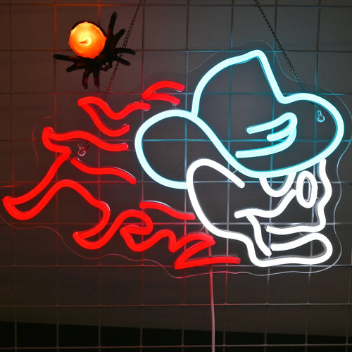 A imagem mostra um letreiro de LED neon vibrante no formato de uma caveira usando um chapéu de cowboy.