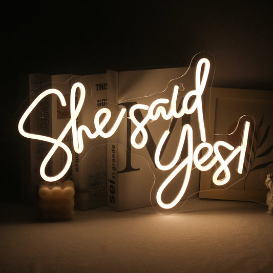 A vibrant, handmade LED neon sign displaying the phrase "She Said Yes.
