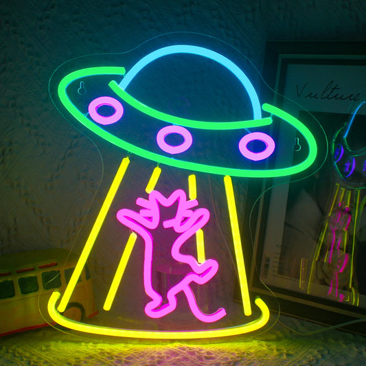The image displays a vibrant LED neon sign shaped like a spaceship.