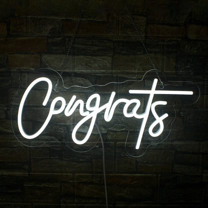 The image features a handmade LED neon sign displaying the word "Congrats" in a stylish, flowing script.