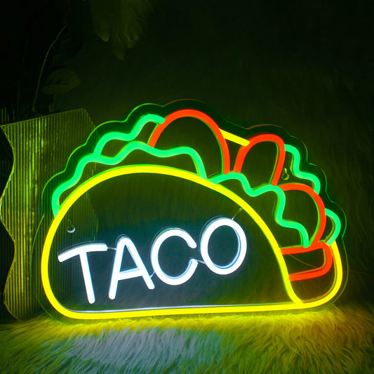 The image features a vibrant LED neon sign shaped to spell the word "Tacos.