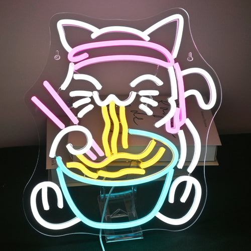 A imagem apresenta uma placa de LED neon vibrante e colorida representando um design excêntrico de um gato saboreando uma tigela de ramen.