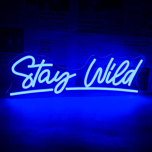 "Uma vibrante placa de LED neon exibindo as palavras 'Stay Wild' em uma fonte cursiva e estilosa.