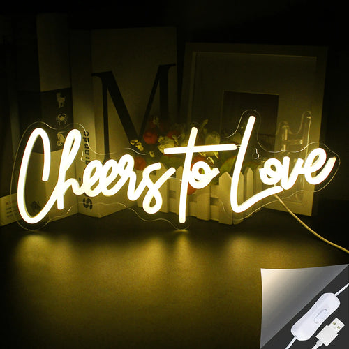 A imagem exibe uma vibrante placa de LED neon feita à mão que diz "Cheers to Love" em uma fonte estilosa.