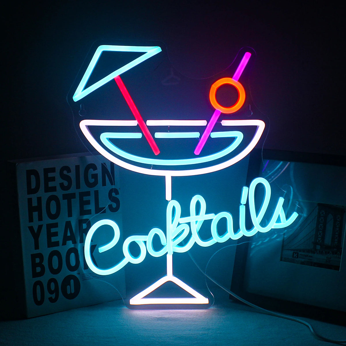 A imagem apresenta uma vibrante placa de LED neon exibindo a palavra "Cocktails" em uma fonte cursiva divertida.