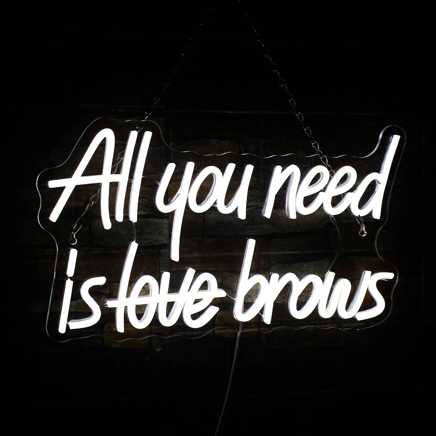 The image displays a vibrant "All you need is brows" LED neon sign.