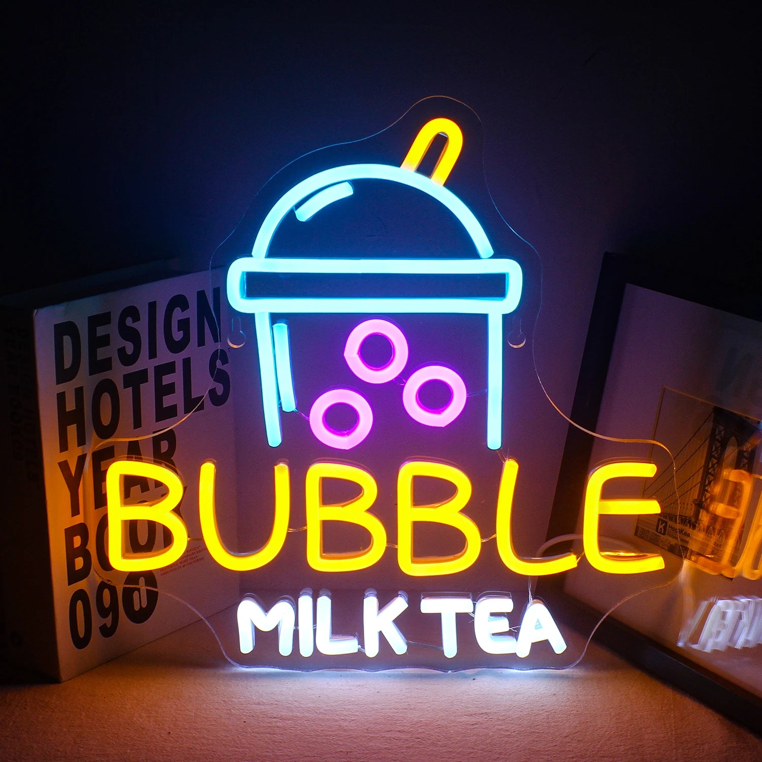 A imagem exibe um letreiro de LED neon vibrante no formato de uma xícara de chá com leite e bolhas.