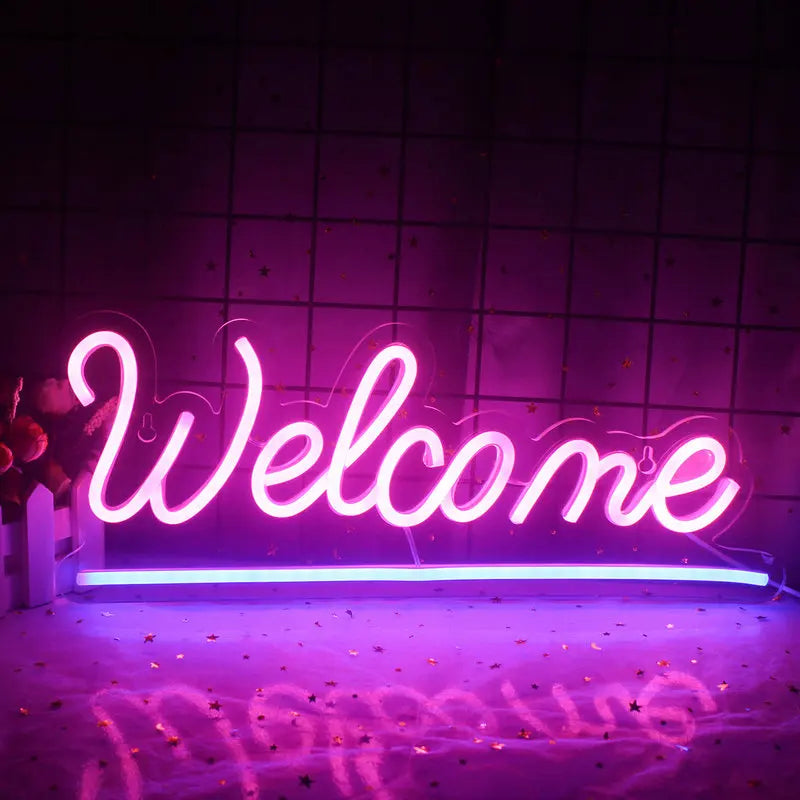 Uma vibrante placa de LED neon com os dizeres "Bem-vindo" exibida em uma parede branca simples.