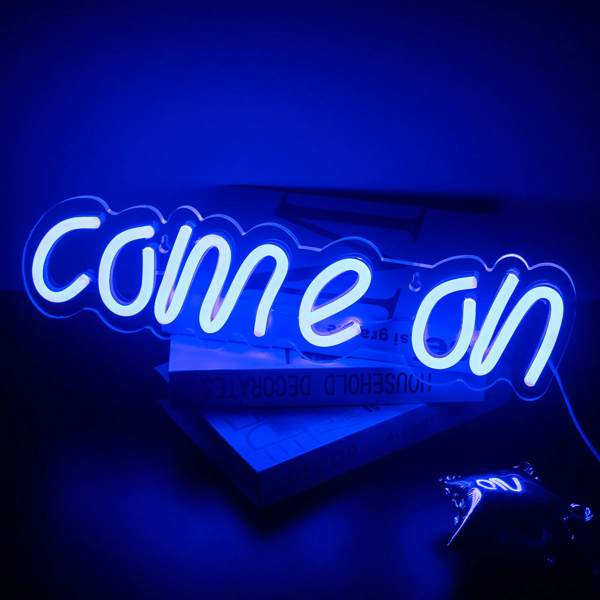 A imagem apresenta uma vibrante placa de LED neon exibindo as palavras "Come On" em uma fonte ousada e divertida.