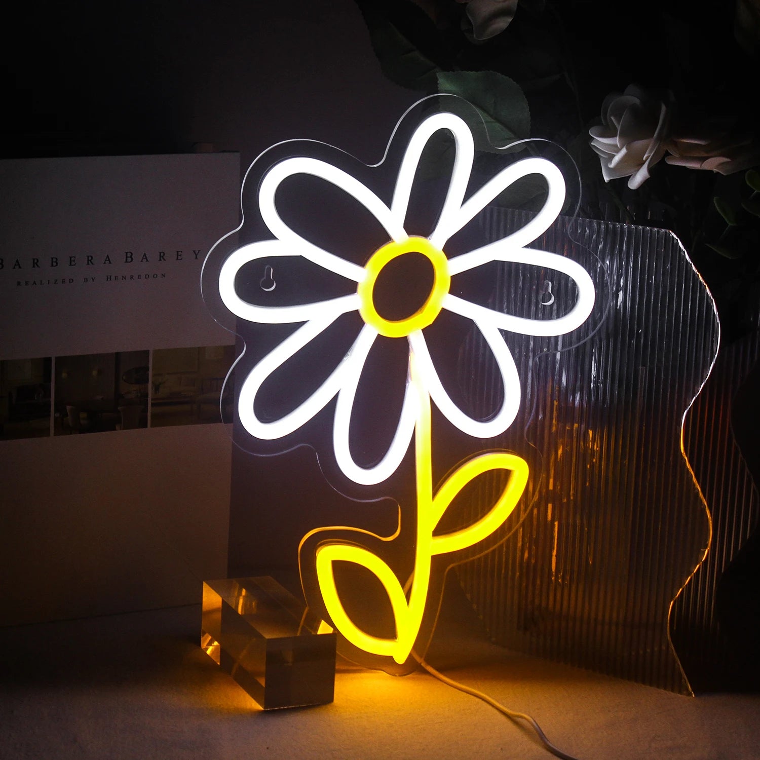The image displays a colorful LED neon sign in the shape of a cute cartoon daisy flower.