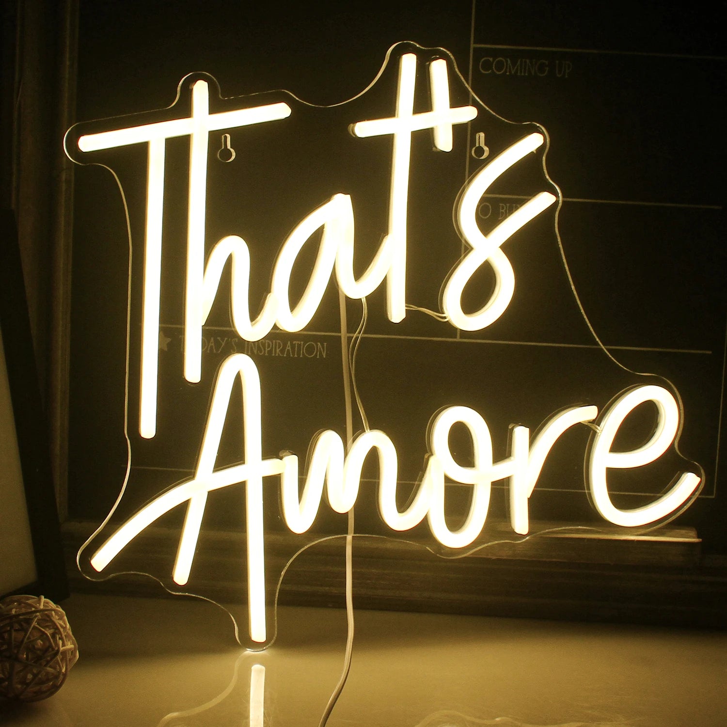 A vibrant handmade LED neon sign displaying the word "Amore" in elegant cursive lettering.