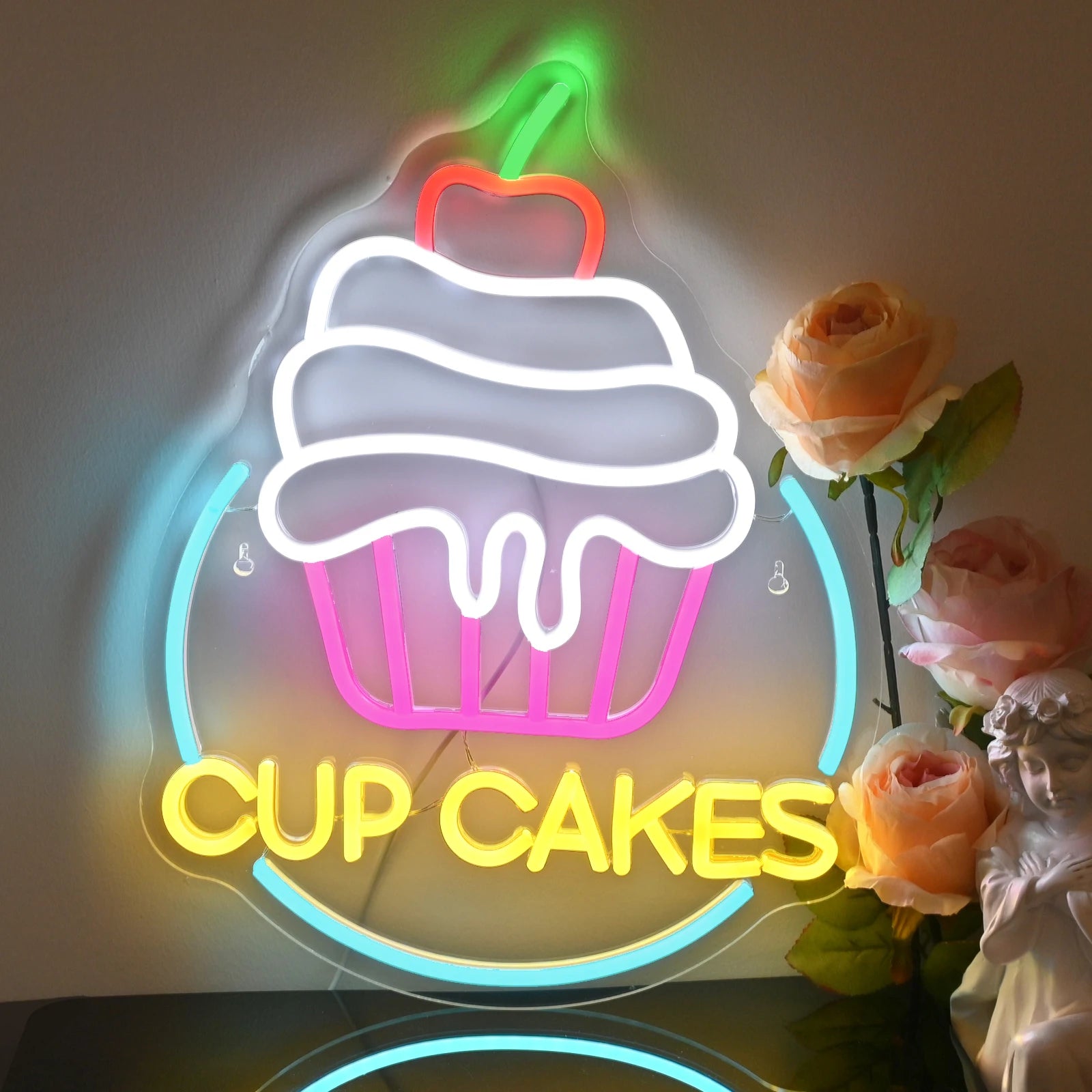 The image showcases a vibrant LED neon sign in the shape of a cupcake.