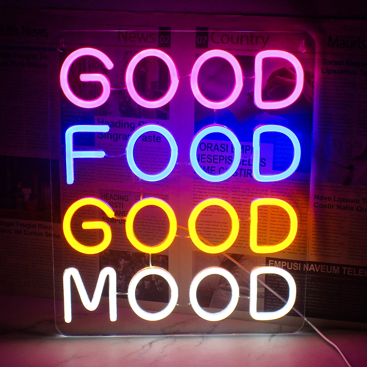 Uma vibrante placa de LED neon exibindo as palavras "Boa comida, bom humor" em uma fonte cursiva divertida.