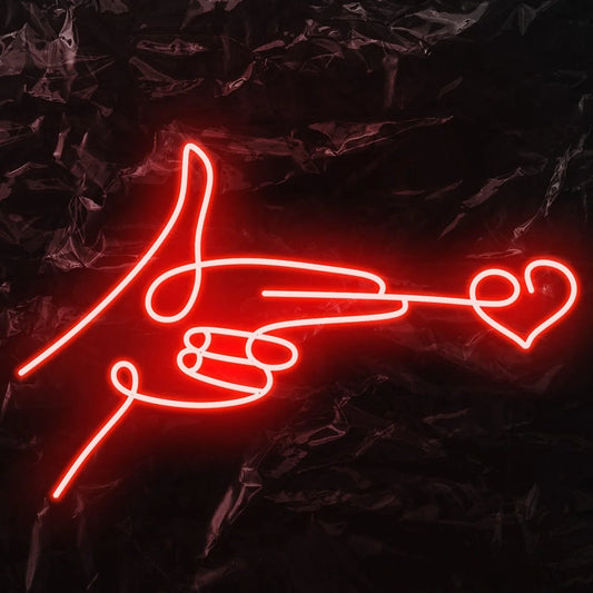 The image displays a vibrant LED neon sign in the shape of a "finger heart" gesture.