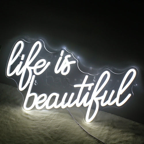 Uma vibrante placa de LED neon feita à mão exibindo a frase "A vida é bela" em uma escrita elegante e fluida.