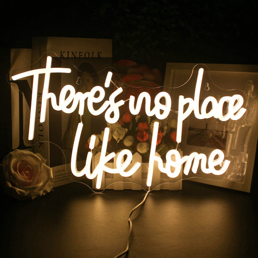 The image features a stylish and vibrant LED neon sign displaying the phrase "There's No Place Like Home.