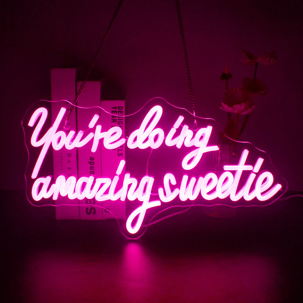 Uma vibrante placa de LED neon exibindo a frase "Você está indo muito bem, querida" em uma letra cursiva elegante.