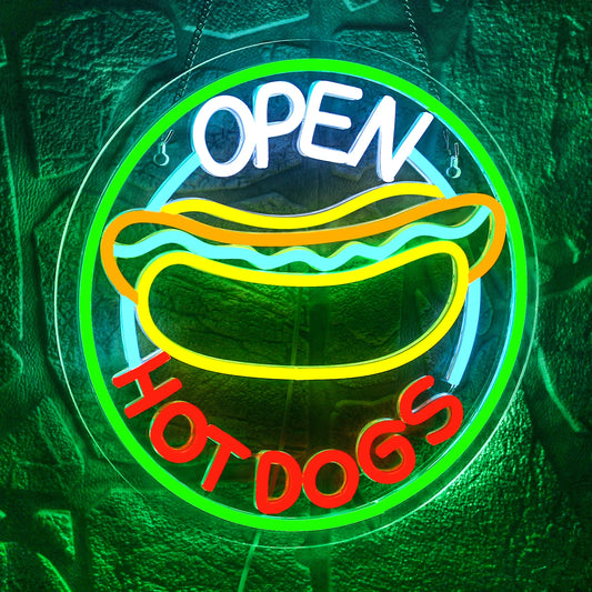The image features a brightly lit LED neon sign displaying the words "Open Hot Dogs" in a playful, retro font.