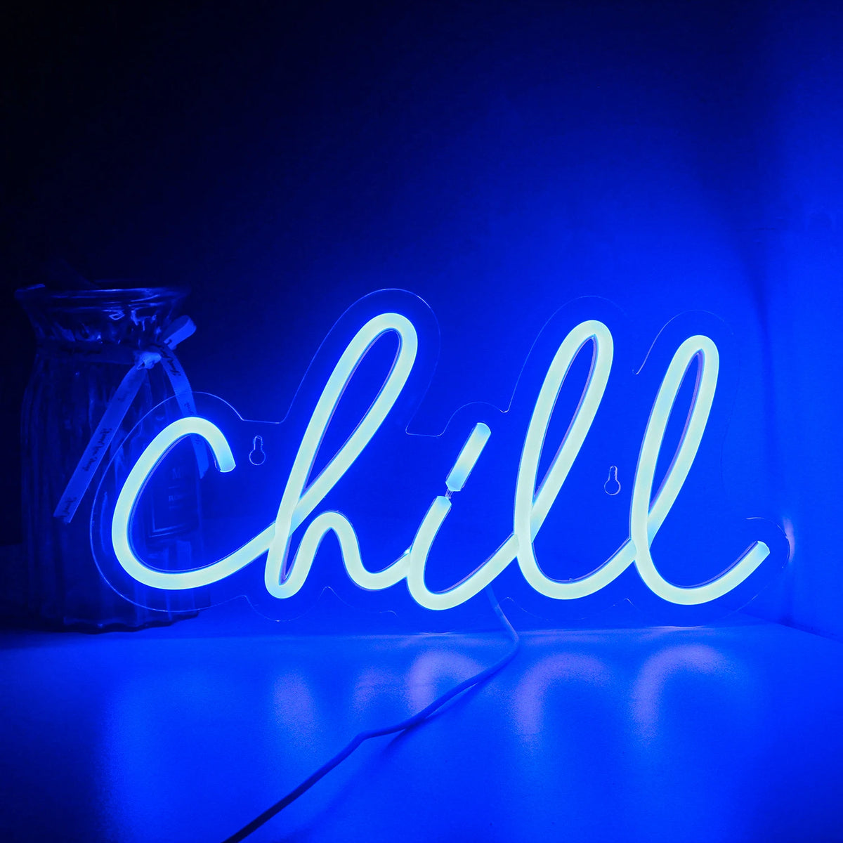 A imagem mostra uma placa de LED neon com a palavra "Chill" escrita em um estilo vibrante e cursivo.