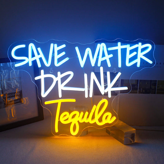 The image features a vibrant LED neon sign displaying the phrase "Save Water Drink Tequila" in bold, playful typography.