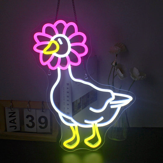The image features a vibrant LED neon sign in the shape of a duck.