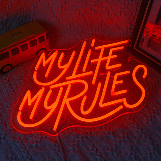A vibrant LED neon sign displaying the words "My Life My Rules" in a lively cursive font.