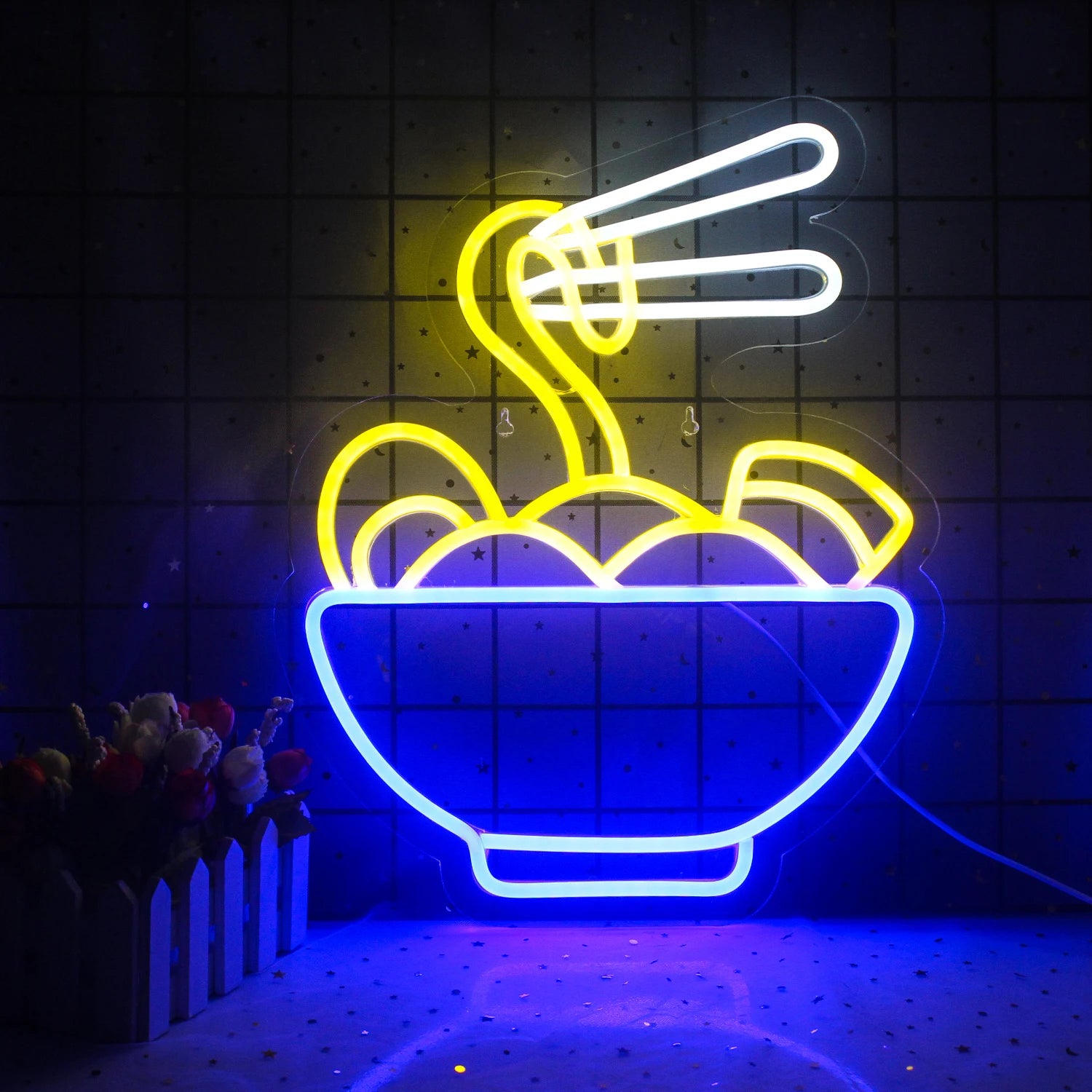 The image features a vibrant LED neon sign showcasing the word "Ramen" in bold, stylized letters.