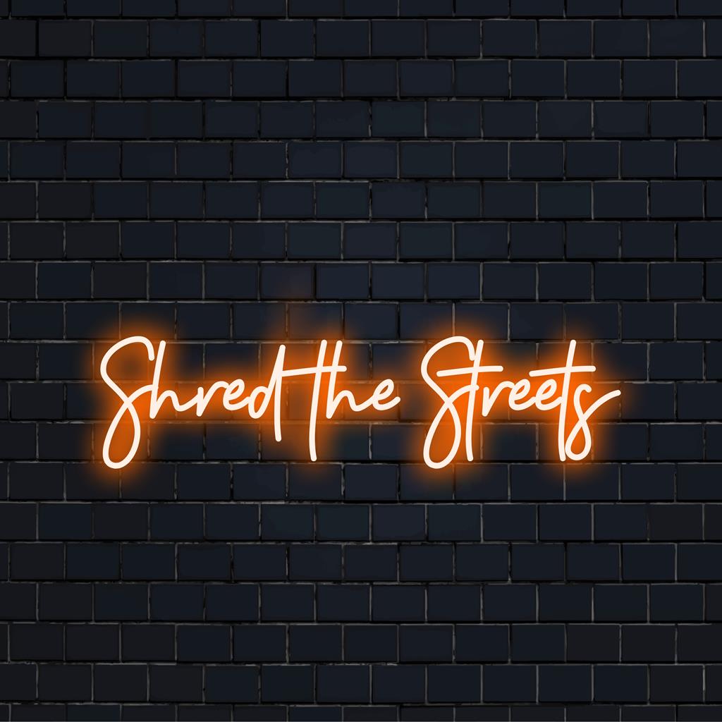 Letreiro de LED neon personalizado com a inscrição "Shred The Streets" em cores vibrantes. Decoração neon perfeita para valorizar qualquer espaço moderno.