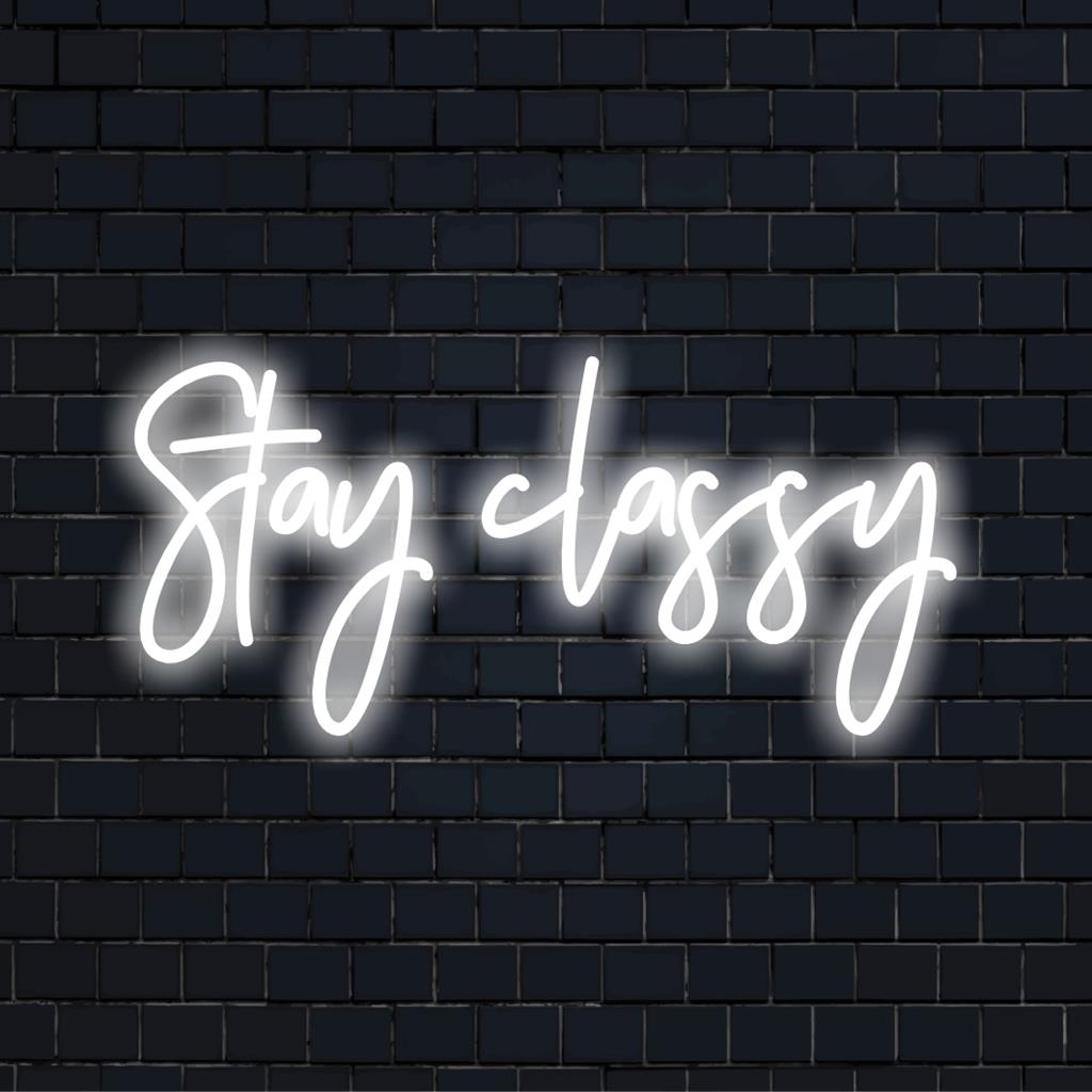 Uma elegante placa de LED neon personalizada com Stay Classy iluminada em cores vibrantes, perfeita para uma decoração de parede elegante.