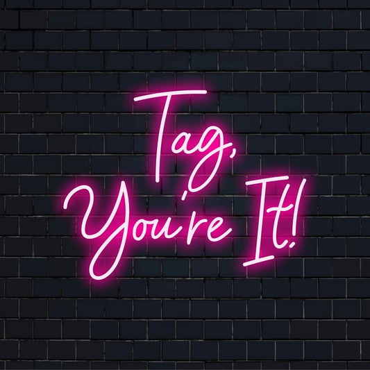 Vibrant custom-made LED neon sign with a playful Tag, You're It! message, perfect for unique lighting decor.